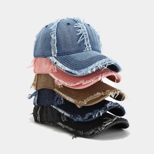 Détail de cinq casquettes en denim délavé montrant des bords effilochés et un style rétro
