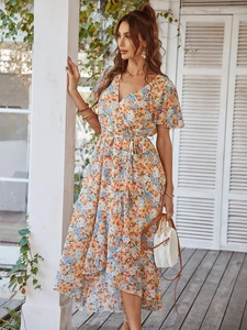 Détail de robe longue fleurie à col en V avec taille nouée et ourlet irrégulier de vacances