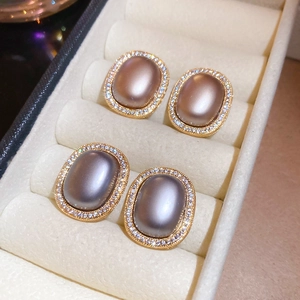 Detail view of oval vintage stud earrings with gold plating and pearl-like stones