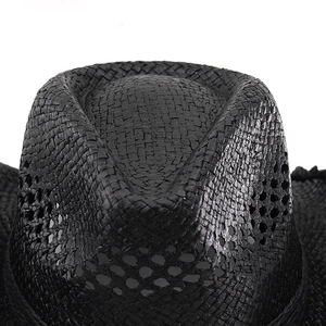 Vue de dessus montrant la paille noire tressée et les trous d'aération du chapeau de cowboy