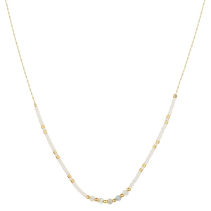 Gros plan du collier doré minimaliste avec perles blanches et pierres naturelles bleues