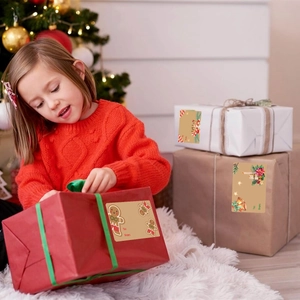 Close-up of Merry Christmas gift tags with gingerbread and holly on gift boxes