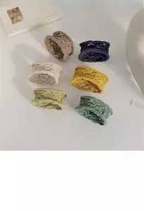 Vue à plat de six chouchous en dentelle aux tons feutrés sur une surface blanche