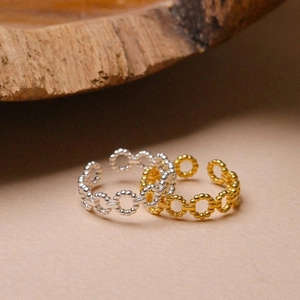 Detail of twisted chain rings in gold and silver finish with adjustable open band