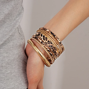 Close-up of stacked leopard print and gold bangles with rhinestone details on wrist