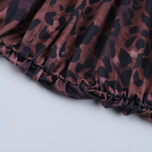 Détail du tissu imprimé léopard avec smocks élastiques et texture satinée soyeuse