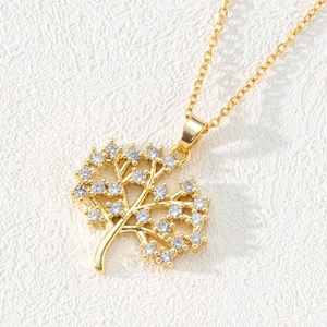 Macro shot of gold-plated Tree of Life pendant with sparkling pavé zircons and fine chain