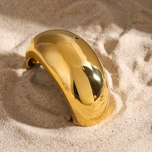 Minimalist wide gold stainless steel hair tie ring on sand with high polish finish