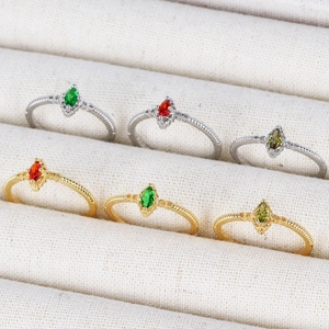 Detailed display of 18K gold and silver rings with marquise-cut zircon stones in a box