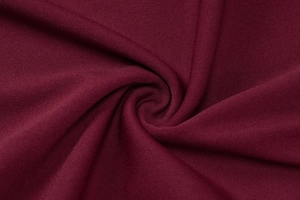 Detail of burgundy red dress fabric showing high-quality knit texture and smooth drape