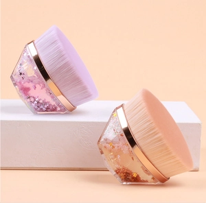 Detail of hexagonal makeup brushes with liquid glitter handles and dense soft bristles