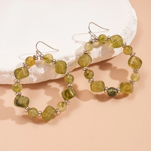 Detailed shot of olive green acrylic beads and silver spheres on boho hoop earrings