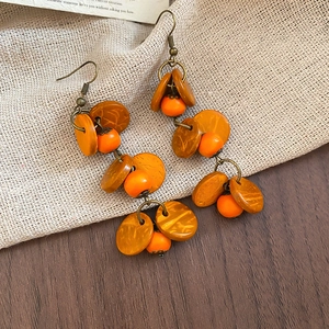 Détail de boucles d'oreilles bohèmes vintage avec perles orange et métal en bronze