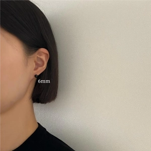 Close-up of 6mm black onyx stud earring on model showcasing minimalist silver design