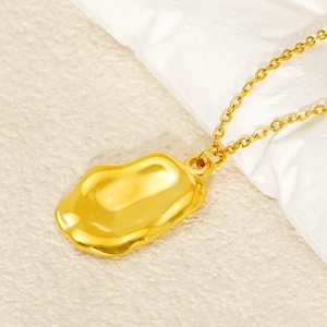 Macro view of gold irregular rectangular pendant with organic texture on link chain