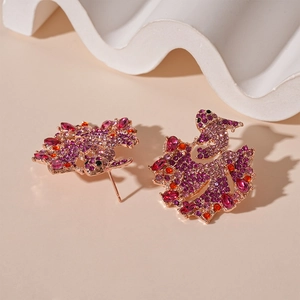 Detailed close-up of koi fish earrings with colorful purple and pink crystals