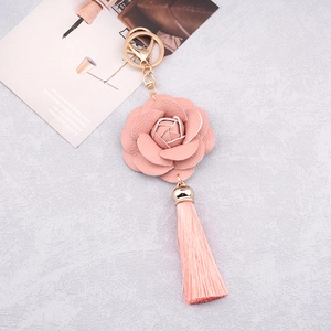 Detail view of a pink PU leather flower charm with matching tassel and gold hardware