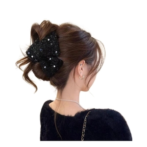 Pince à cheveux élégante en tweed noir avec paillettes vue de dos sur les cheveux