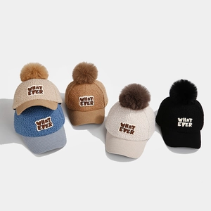 Detailansicht der bunten Winter-Kinderkappen mit Pompon und weicher Lammwolle-Textur