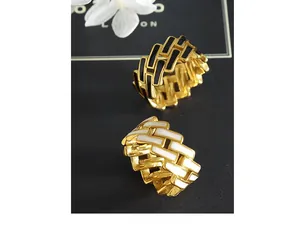 Detail of interlocking enamel rings with black and white grid patterns on gold band