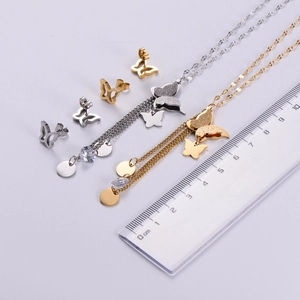 Macro scale shot of gold and silver butterfly pendant necklaces and stud earrings