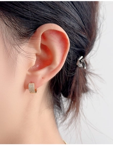 Close-up of gold-plated S925 sterling silver hoop earrings with pavé-set sparkling crystals