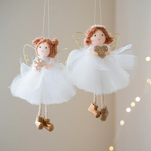 Christmas angel doll with white mesh skirt and gold wings hanging on light background