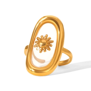 Detailed close-up of golden oval ring featuring a sun emblem and transparent inlay