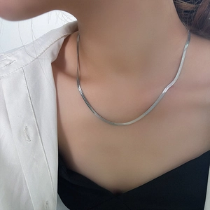 Polished silver titanium steel herringbone chain necklace shown on a female neck