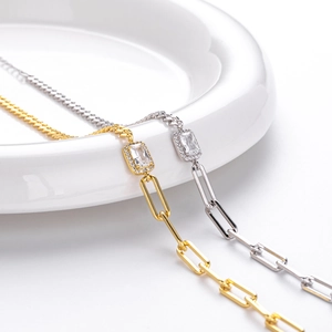 Detail of S925 sterling silver paperclip bracelets in gold and silver with square zircons