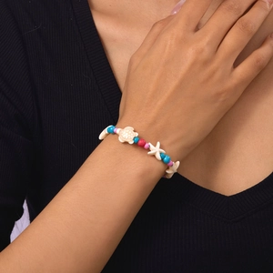 Detail of ocean-themed beaded bracelet featuring white turtle and starfish charms