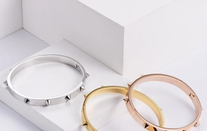 Three-color stack of stainless steel rivet bangles in silver, gold, and rose gold finishes
