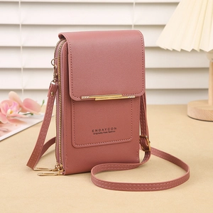 Detail of crossbody phone bag in dusty pink with textured leather and gold metal trim