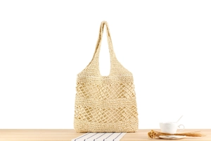 Detail of hollow woven paper rope tote bag with natural wavy texture and ivory finish