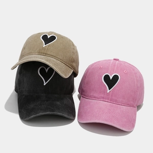 Washed cotton baseball caps with heart embroidery in khaki, black, and pink colors