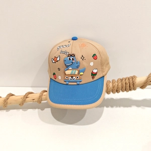 Detailed close-up of a khaki and blue baseball cap with a 3D cartoon dinosaur and car design