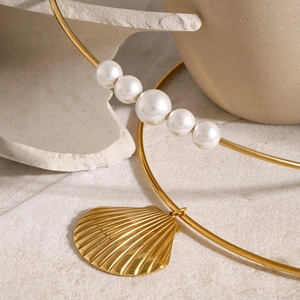 Detailed view of 18k gold plated necklace with sea shell pendant and white pearls