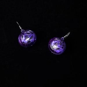 Close-up of translucent purple LED pumpkin earrings for Halloween glow outfits