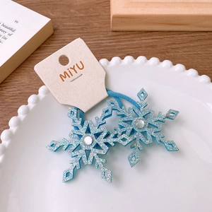 Detail of blue glitter snowflake hair clips with rhinestones on a white ceramic plate