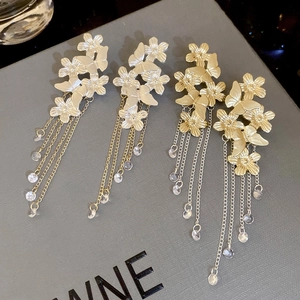 Close-up of butterfly floral tassel earrings with silver needles and crystal charms