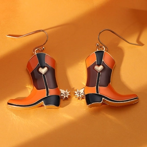 Detail of western cowboy boot earrings with orange enamel hearts and golden accents