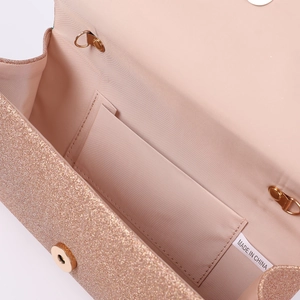 Macro view of rose gold sequin evening bag featuring pink fabric lining and magnet closure