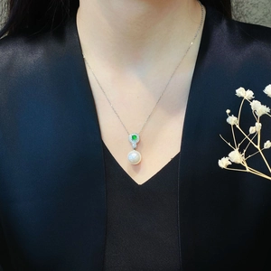 Elegant green chalcedony and white pearl pendant necklace worn on a black dress