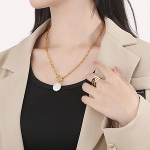 Baroque pearl necklace and multi-layer ring set worn on a khaki blazer outfit