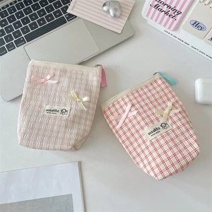 Close-up of seersucker plaid pouches with bow detail and colorful fringe tassels