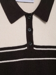 Detailed view of the rib-knit texture and buttoned polo collar on a striped beige top