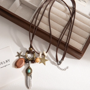 Bohemian feathered long necklace with star beads and turquoise stone on a wooden tray