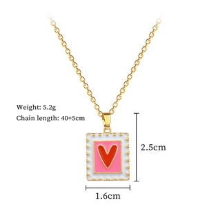 Detail of square gold pendant with red heart, pink inlay, and size specs 2.5x1.6cm