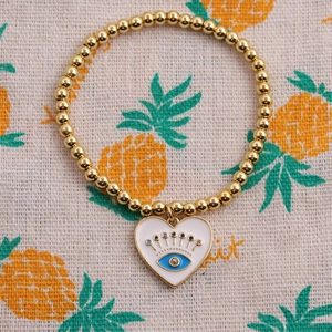 Golden stretch bead bracelet featuring white heart evil eye charm with colorful details