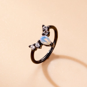 Macro shot of black V-shaped nose ring with pear-shaped opal and round clear gems